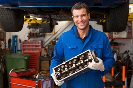 Wartung & Service: Mechaniker mit Teil eines Motors